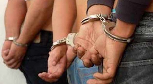 Tres detenidos, esposados