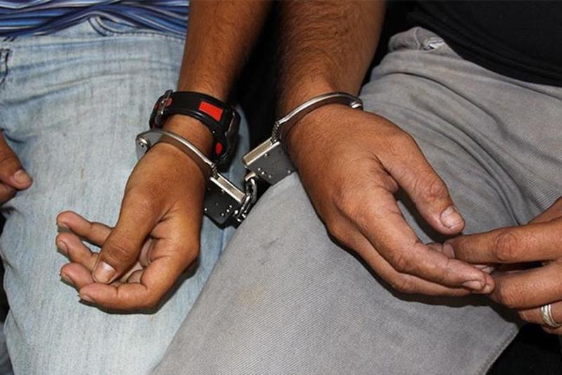 Dos detenidos, esposados