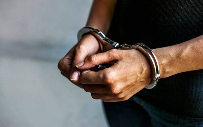 Detenido, esposado
