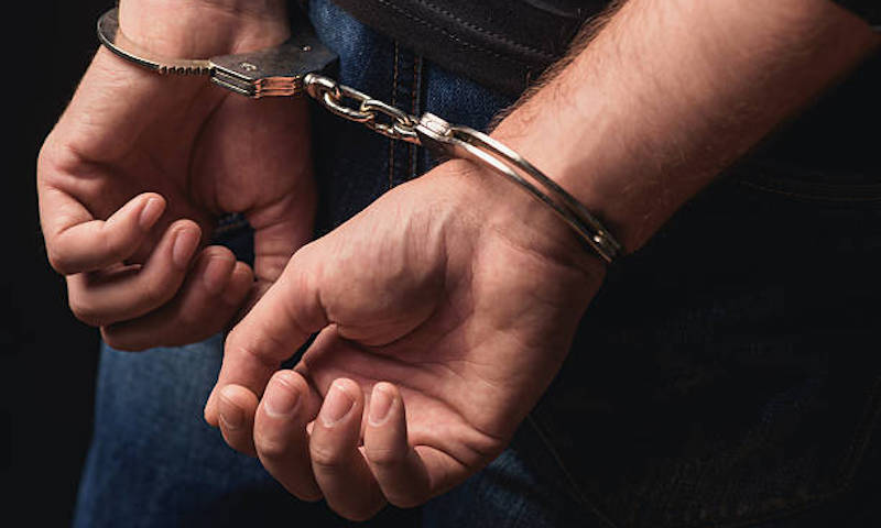 Detenido, esposado