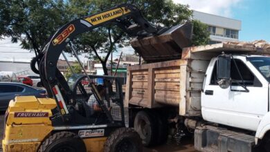 Retroexcavadora arroja tierra dentro de un camión de volteo