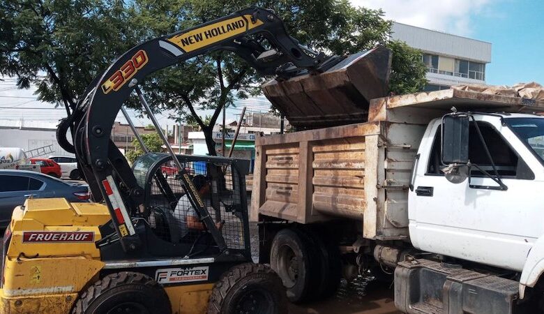 Retroexcavadora arroja tierra dentro de un camión de volteo