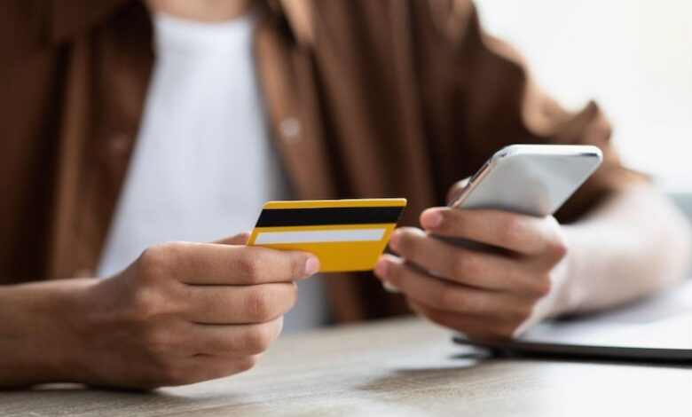 Hombre con tarjeta de crédito y celular