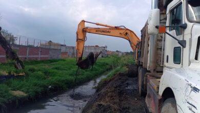 Maquinaria desazolvando un dren