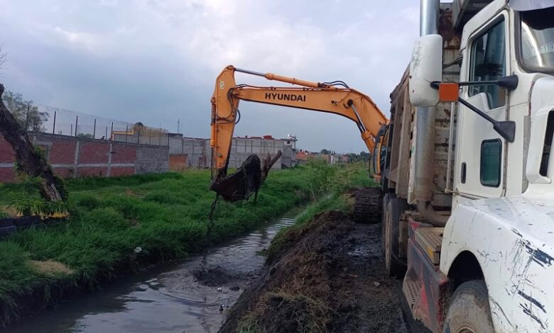 Maquinaria desazolvando un dren